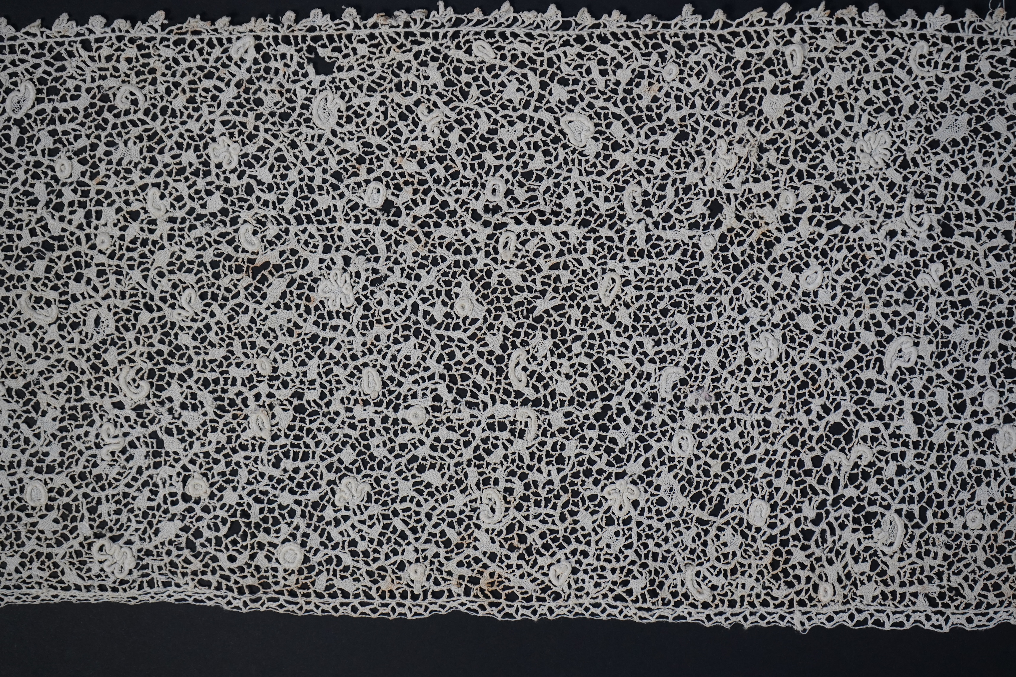 A late 17th century wide flounce of Point de France needle lace, together with a narrower flounce, both with raised elements of the design in the style of Point de Rose, but less so. This lace was very popular with the F